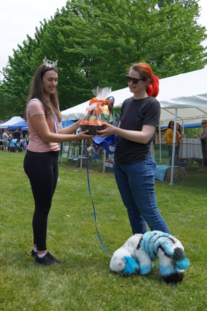 A photo presenting a dog owner with a raffle basket at the Barks and Recreation event in 2023